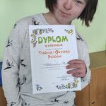 Uczennica  prezentuje dyplom otrzymany w konkursie plastycznym.