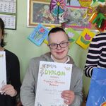 Uczniowie prezentują dyplomy otrzymane w konkursie plastycznym.