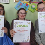 Uczniowie prezentują dyplomy otrzymane za udział w konkursie plastycznym.