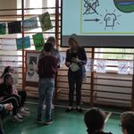 Nauczycielka wręcz dyplom uczniowi za udział w konkursie plastycznym.