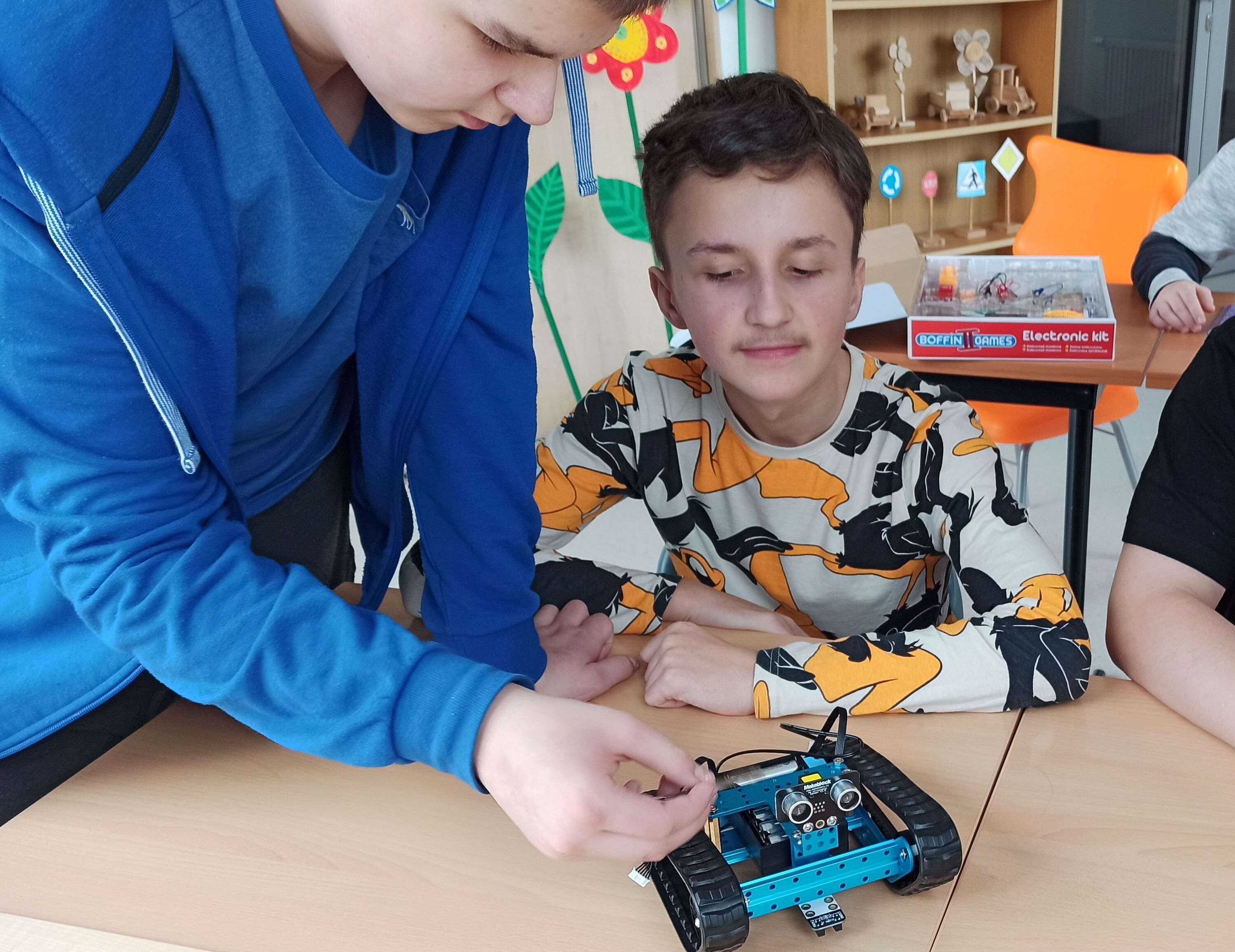 Uczniowie demonstrują wykonanego przez siebie robota.