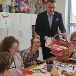 Wiceprezydent Rafał Rudnicki rozdaje uczniom flagi.