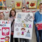 Uczniowie pokazują wykonane na warsztatach plakaty.