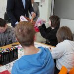 Wiceprezydent Rafał Rudnicki rozdaje uczniom flagi.
