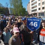 Grupa uczniów stoi z tarczą szkoły