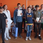 Grupa nauczycieli i uczniów z dyplomami i nagrodami