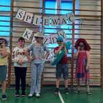 Grupa uczniów w przebraniach w trakcie występu.