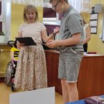 Uczeń recytuje wiersz. Obok stoi nauczycielka.