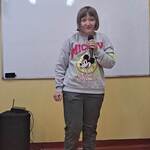 Uczennica mówi wiersz do mikrofonu.