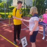 Uczeń odbiera medal z rąk organizatorki.