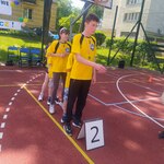 Uczniowie stoją jeden za drugim za tabliczką z napisem  numer 2.
