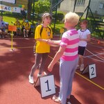 Uczennica odbiera medal z rąk organizatorki.