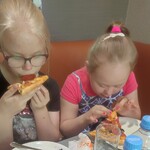 Dziewczynki jedzą pizzę,