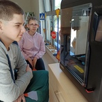 Uczniowie patrzą na drukarkę 3D