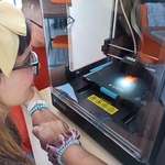 Uczennica patrzy na drukarkę 3D