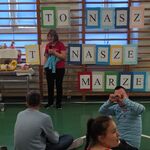 Uczennica i nauczycielka  stoją na tle drabinek z napisem ,,To nasz świat, nasze marzenia